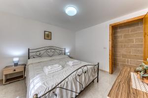 a bedroom with a bed and a brick wall at Pilella in Alliste