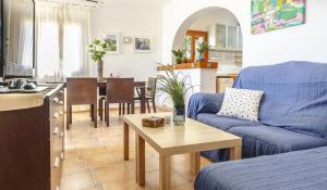 a living room with a blue couch and a table at Vistas a Moraira in Teulada +9 photos