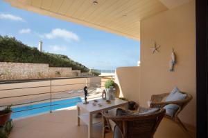 a patio with a table and chairs on a balcony at Praia Areia Branca in Lourinhã