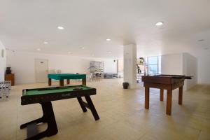 two ping pong tables in a room with a pool table at Praia Areia Branca in Lourinhã
