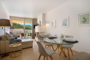 a living room with a table and chairs and a couch at Praia Areia Branca in Lourinhã