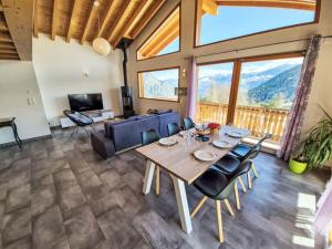 a dining room with a table and chairs and a couch at Chalet Alpina by Interhome in Ovronnaz