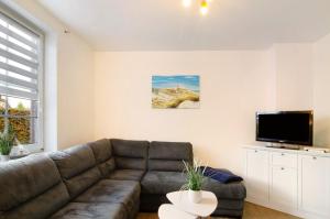 a living room with a couch and a flat screen tv at Ferienwohnungen Schmitz in Wangerland