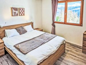 a bedroom with a large bed with a window at Chalet Alpina by Interhome in Ovronnaz