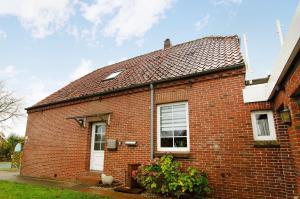 a red brick house with a red roof at Ferienwohnungen Schmitz in Wangerland