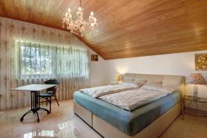 a bedroom with a bed and a table and a chandelier at Villa Galerie in Hohenwart +54 photos