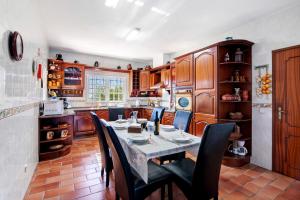 a kitchen with a table and chairs in a room at Quinta da Violeta in Loulé