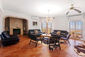 a living room with black furniture and a fireplace at Quinta da Violeta in Loulé