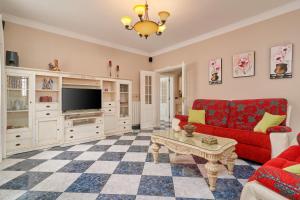 a living room with a red couch and a tv at Villa Soraida in Ítrabo