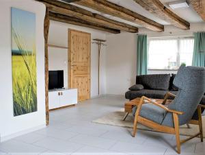 a living room with a couch and a chair at Ferienwohnung Die Schmiede in Schopfloch