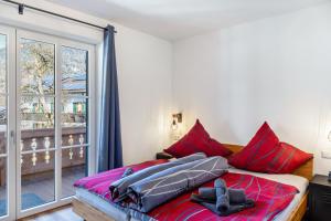 a bedroom with a bed with red pillows and a window at Beim Klarwein in Farchant