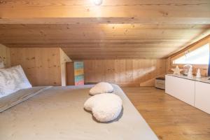 a large bed in a room with wooden walls at Petit Chalet Cosy in Combloux