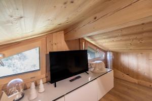 a living room with a flat screen tv in a tiny house at Petit Chalet Cosy in Combloux