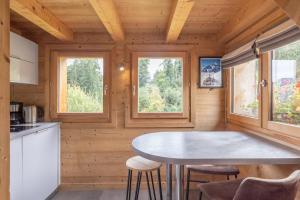 a small kitchen with a table and two windows at Petit Chalet Cosy in Combloux +18 photos