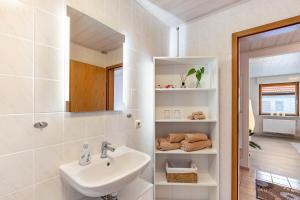 a white bathroom with a sink and a mirror at Ferienwohnung Brigitte in Forbach +13 photos