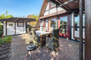 a patio with a table and chairs and an umbrella at Arosa in Bachenbrock