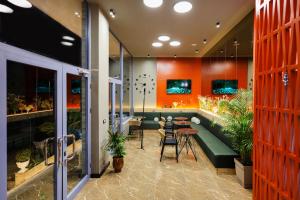 a lobby with a green couch and tables and plants at Grand Hostel Berat in Berat