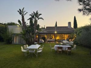 a yard with tables and chairs and a house at Villa Rompido in Cartaya