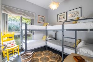 a room with three bunk beds and a yellow chair at Villa Rompido in Cartaya +22 photos