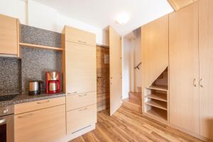 a kitchen with wooden cabinets and a staircase at Sonnleiten der kleinen Bären 9 in Collepietra