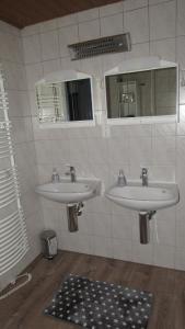 a bathroom with two sinks and a mirror at Ferienwohnung Schopper in Halblech +10 photos