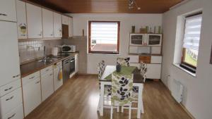 a kitchen with a table and chairs in a room at Ferienwohnung Schopper in Halblech