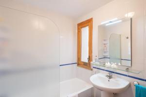 a white bathroom with a sink and a mirror at Santa Eulalia in Can Picafort +20 photos