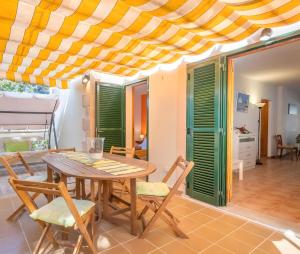 a dining room with a wooden table and chairs at Santa Eulalia in Can Picafort