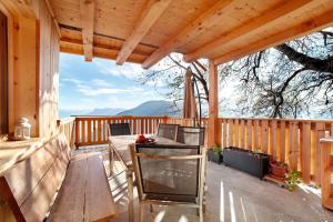 a patio with a table and chairs on a deck at Hauserhof in Lagundo