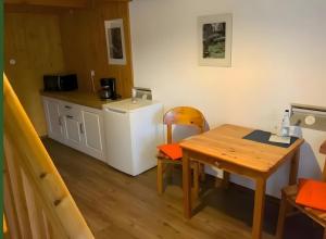 a small kitchen with a table and a refrigerator at Hotel Schachten in Lindberg +26 photos