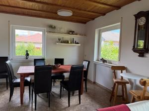 a dining room with a table and chairs and two windows at Casa Jo und Jo in Pfullendorf