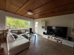a living room with a couch and a flat screen tv at Casa Jo und Jo in Pfullendorf