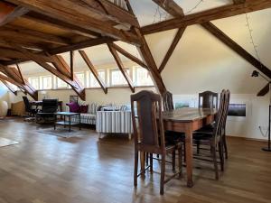 a living room with a wooden table and chairs at Vorwerk Biensdorf in Lichtenau