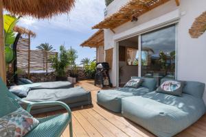 a patio with couches and chairs on a wooden deck at Oceania Villa B, Private Pool in Chayofa