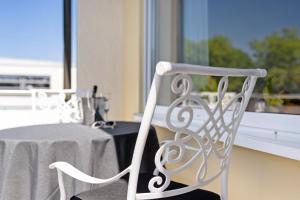 a white chair sitting in front of a table at Andrea in Langenargen