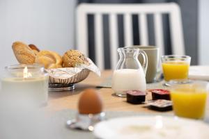 a table with a breakfast of eggs bread and milk at Andrea in Langenargen