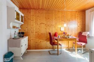 a kitchen with a wooden wall with a table and chairs at Haus Am Bühl in Schönau im Schwarzwald