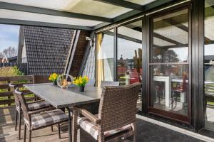 a table and chairs on a patio with glass doors at Sonnenschein Am Meer in Butjadingen