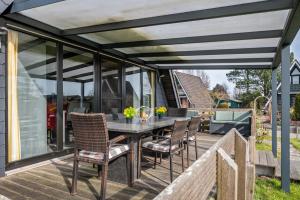 a patio with a table and chairs on a deck at Sonnenschein Am Meer in Butjadingen