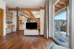 a living room with a tv and a large window at Obst- und Ferienhof Lehle in Immenstaad am Bodensee