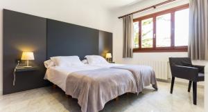 a bedroom with a large bed and a chair at Ca Nostra in Son Servera +22 photos