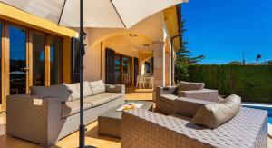 a patio with two couches and an umbrella at Ca Nostra in Son Servera