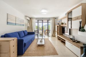 a living room with a blue couch and a table at Casita en Cala Llonga in Cala Llonga