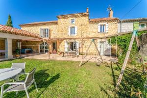 an external view of a house with a table and chairs at Lila Mas in Camaret-sur-Aigues