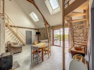 a living room with a table and chairs and stairs at Maison authentique et au calme in Beynat