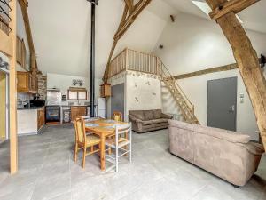 a kitchen and living room with a table and a couch at Maison authentique et au calme in Beynat