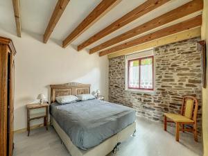 a bedroom with a bed and a stone wall at Maison authentique et au calme in Beynat