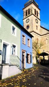 a building with a tower with a clock on it at Kleines Stadthaus mit Sauna in Hillesheim