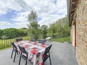 a patio with a table and chairs on a balcony at Maison authentique et au calme in Beynat +6 photos