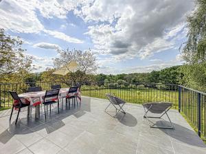 a patio with a table and chairs and a fence at Maison authentique et au calme in Beynat